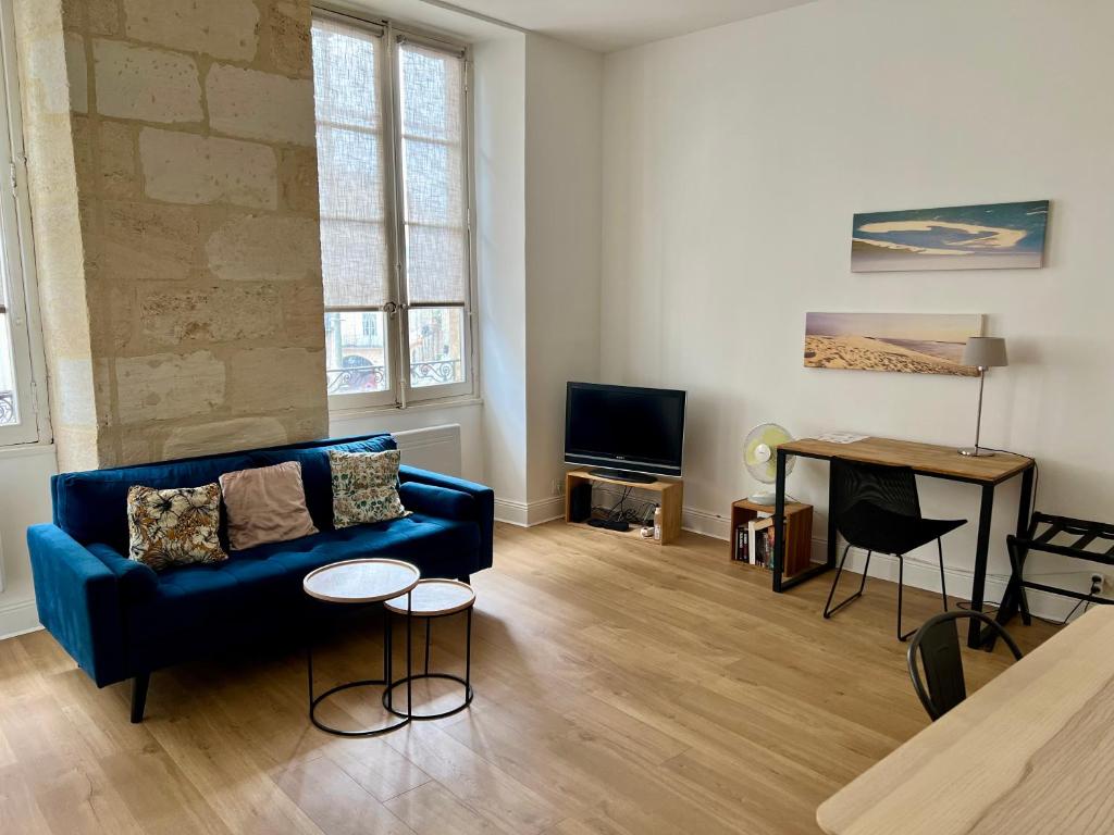 un salon avec un canapé bleu et une table dans l'établissement alsace, à Bordeaux