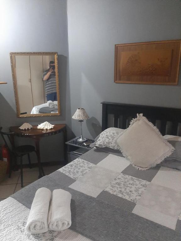 a bedroom with a bed and a mirror at AD'S Overnight Accommodation in Richards Bay