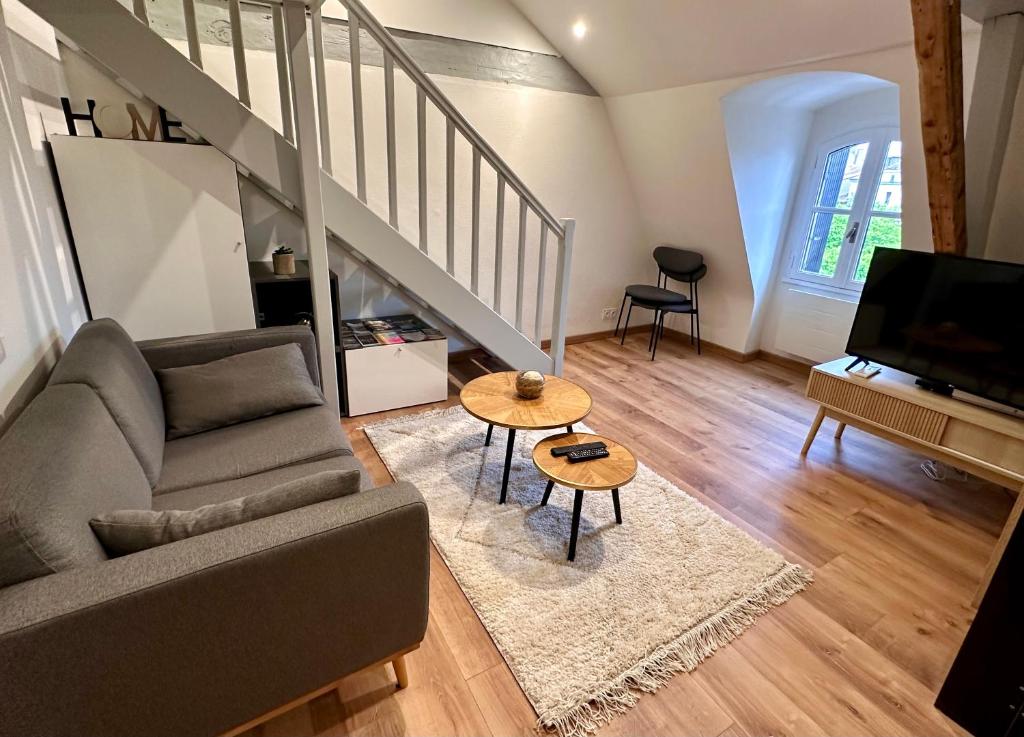 un salon avec un canapé et une table dans l'établissement L'Elégant Charmant appartement centre historique, à Bergerac