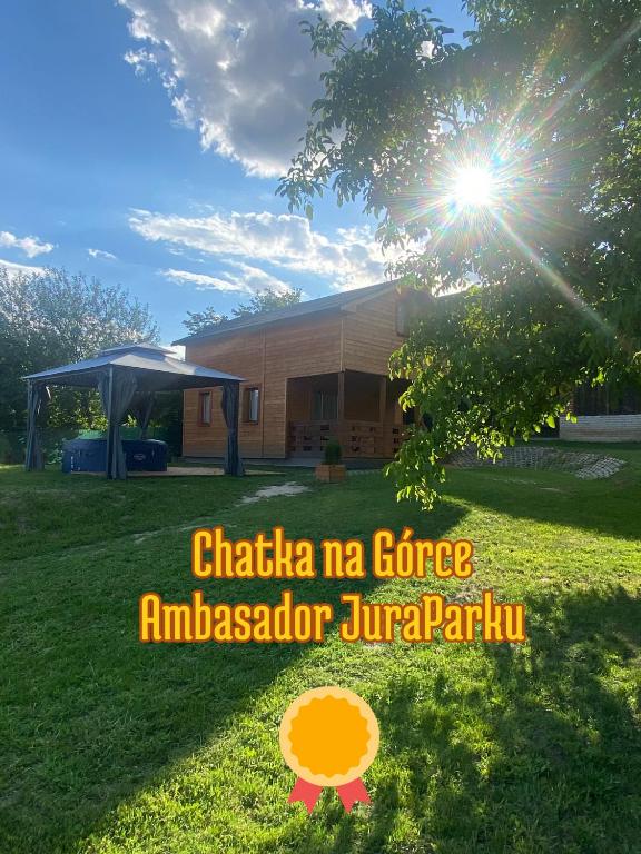a house with the sun shining on the grass at Chatka na Górce in Okół
