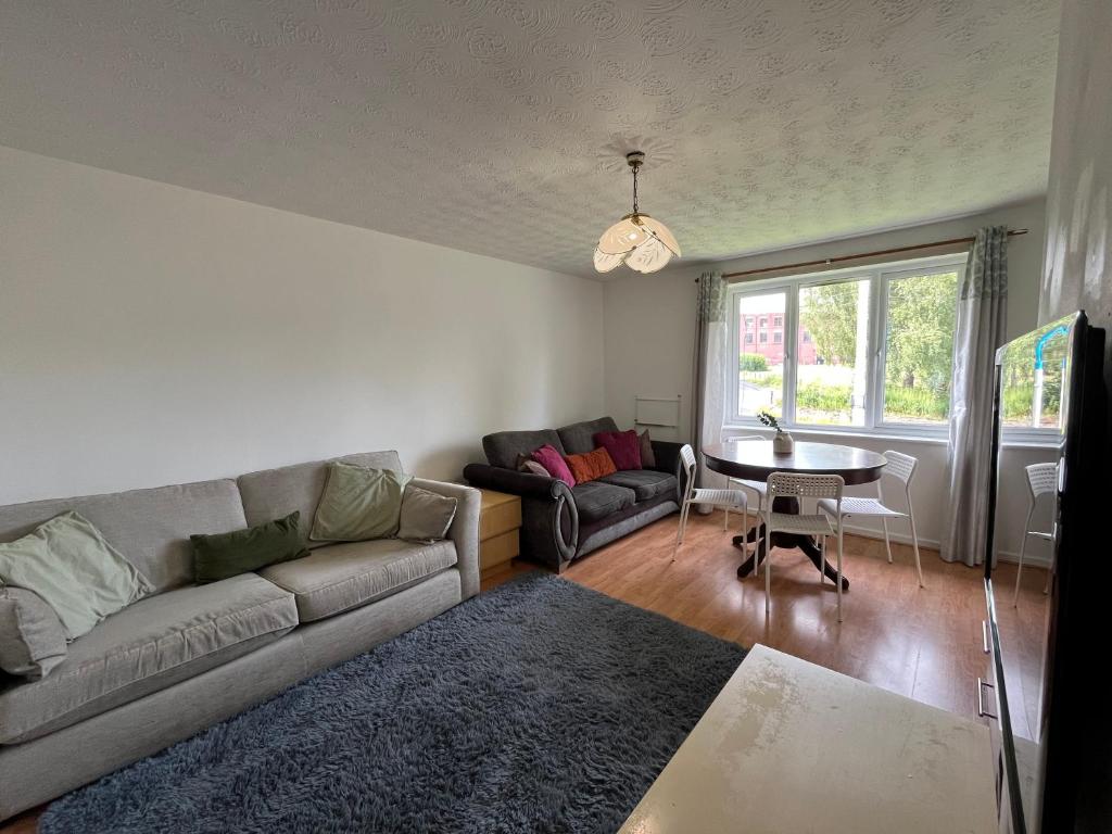 a living room with a couch and a table at Cosy 2 Bedroom Apartment near City Centre in Manchester