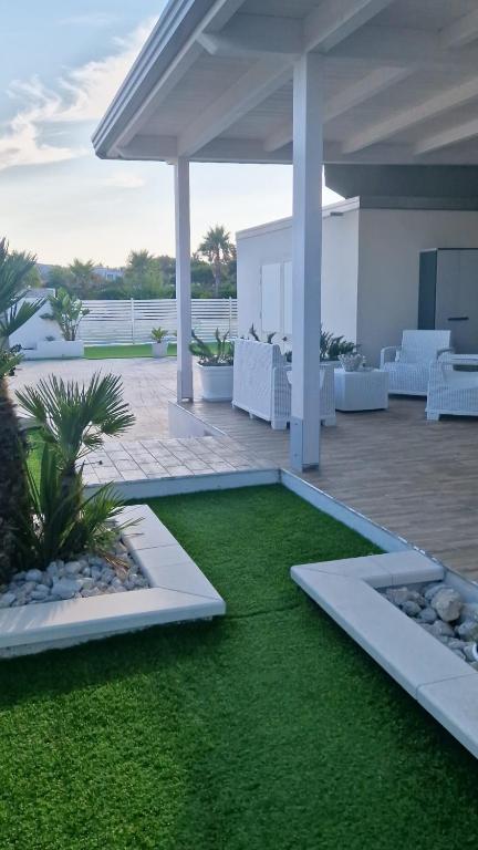 a patio with a grass yard with a pavilion at Podilimbo - Ilios e Thalassa in Paestum
