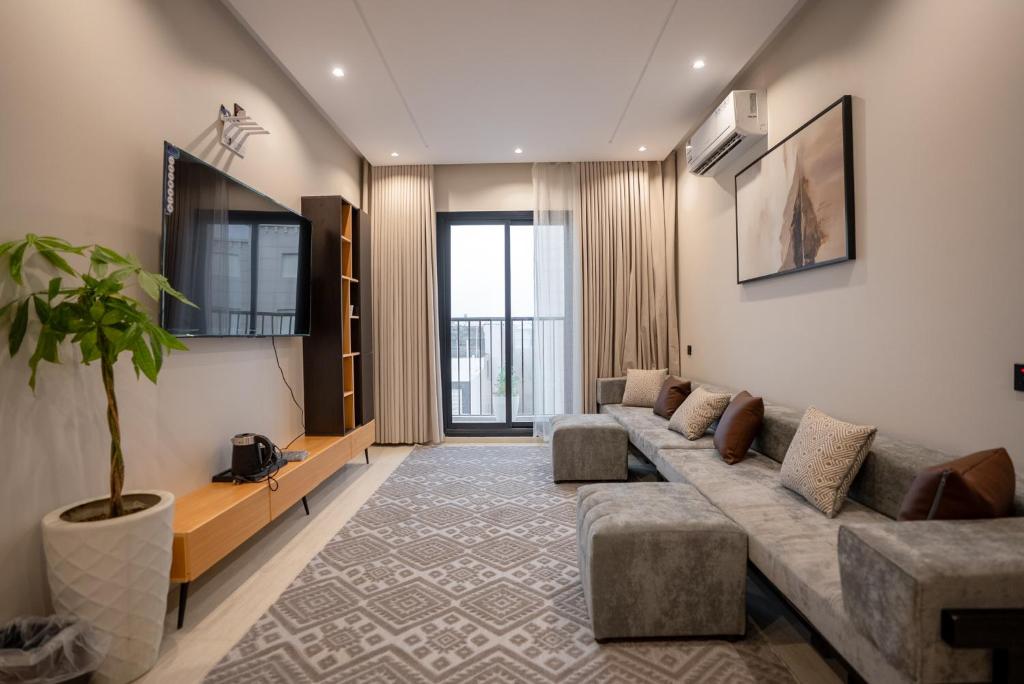 a living room with a couch and a tv at الرابية - شقق فارهة - دخـول ذكي in Abha