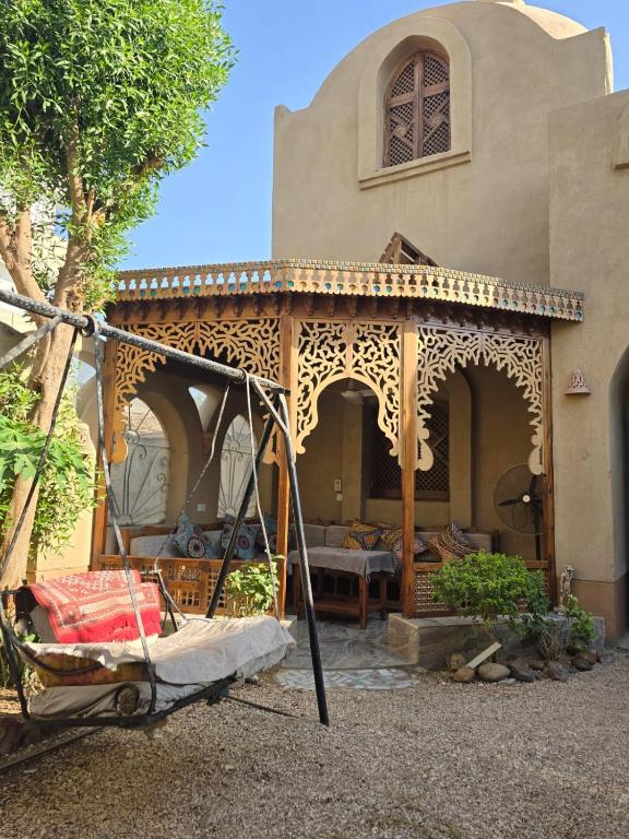 a house with a porch with a bed in it at Villa Harmony Luxor in Luxor