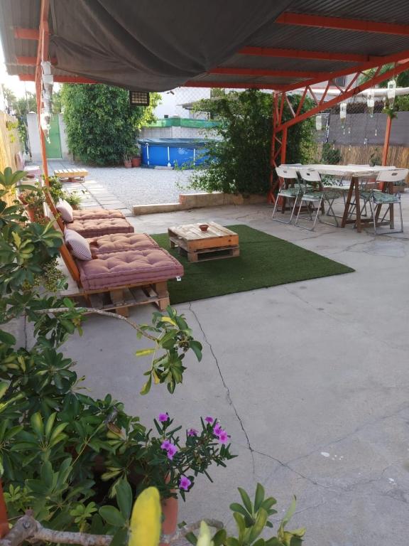 a patio with a bench and tables and a tent at EBREHOME in Deltebre
