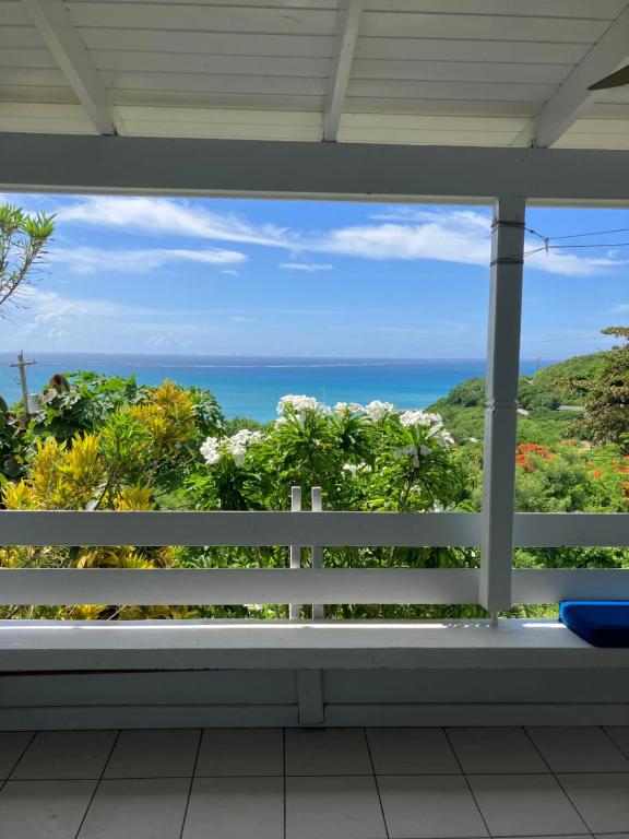a view of the ocean from the porch of a house at Paradise View at Halcyon Heights l Stunning Ocean View 1BR l 10 minute walk to the Beach in Dickenson Bay