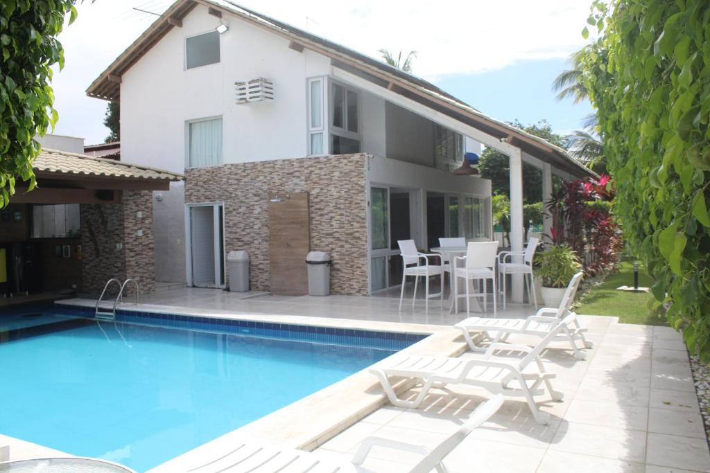 a villa with a swimming pool and a house at Casa Luxuosa - Porto de Galinhas in Porto De Galinhas