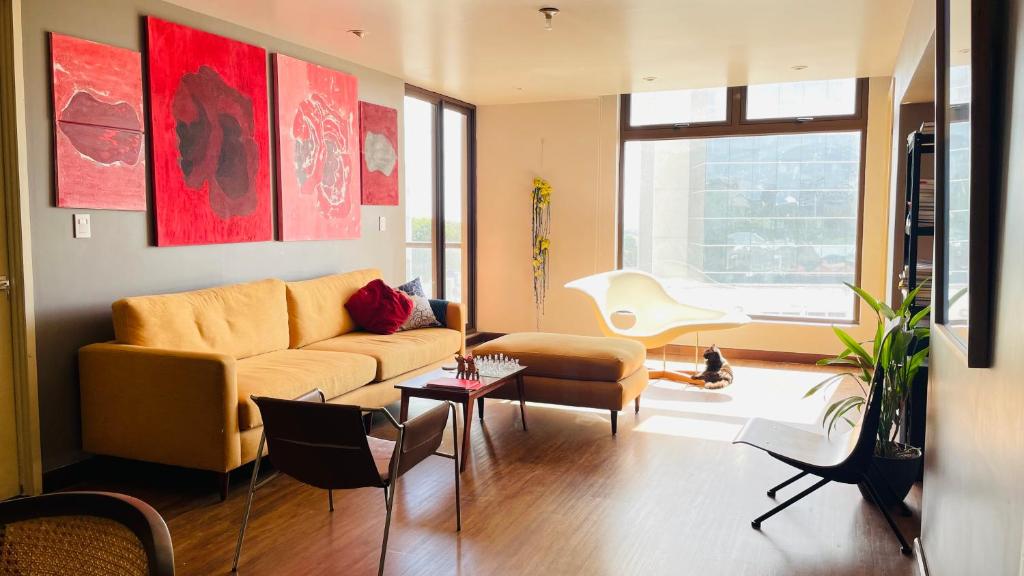 ein Wohnzimmer mit Sofa und Tisch in der Unterkunft Apartamento bellamente decorado en la zona 10 in La Aurora