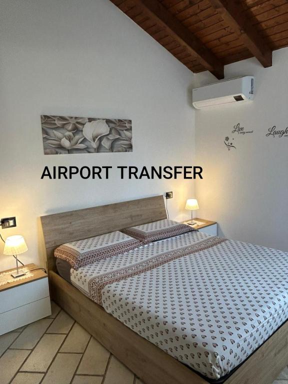 a bedroom with a bed with an airport transfer sign on the wall at MXP apartment, shuttle service, parking free in Cardano al Campo
