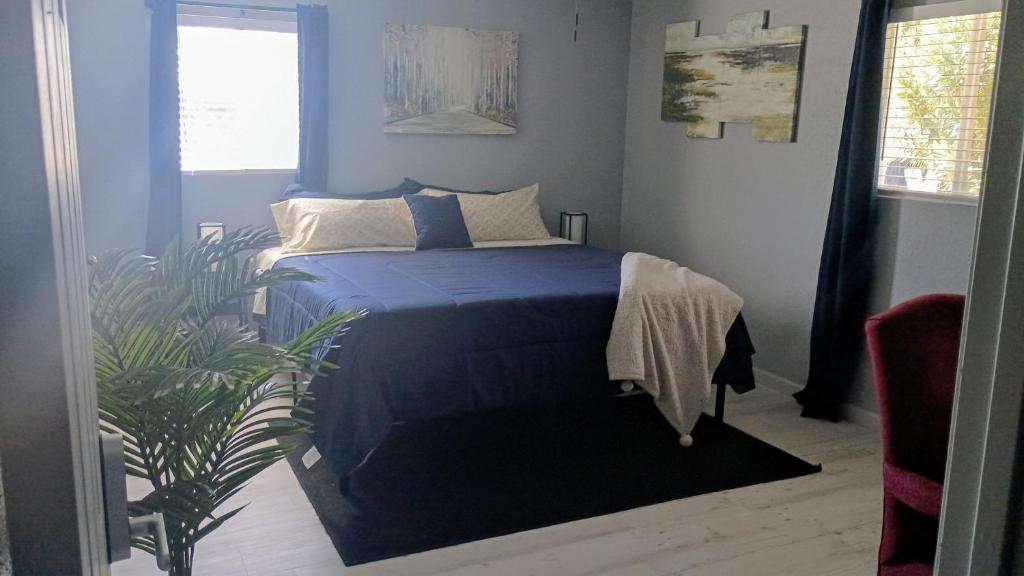a bedroom with a bed with blue sheets and a plant at Modern Industrial Oasis Private Room with King Bed WiFi FREE Parking and More in Alamogordo