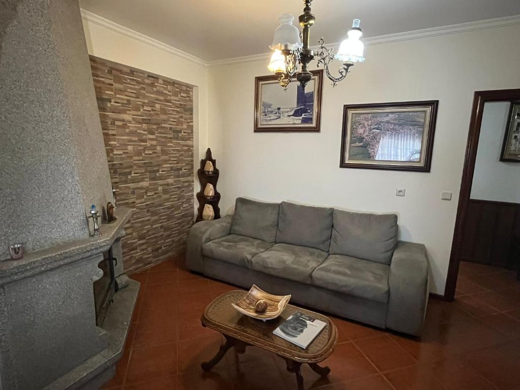 una sala de estar con un sofá y una mesa en Refúgio do Sabor, en Mogadouro