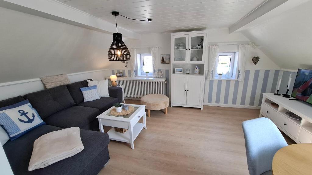 a living room with a couch and a table at Ferienwohnung Achterdeck - Alte Schmiede Neugarmssiel in Wangerland