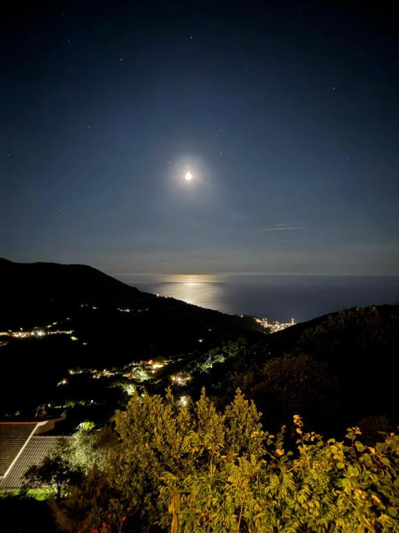 a night view of a city and the moon at Bed&Breakfast Bella Vita in Moneglia