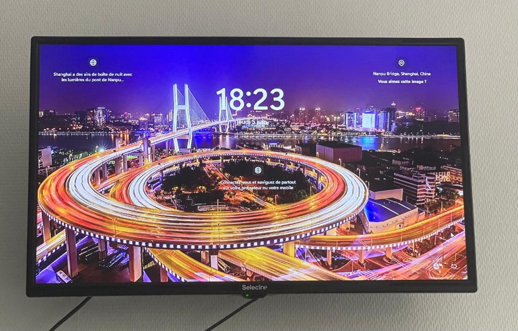 una pantalla de televisión con una imagen de una ciudad en Great apartment avec stationnement, en Saint-Étienne