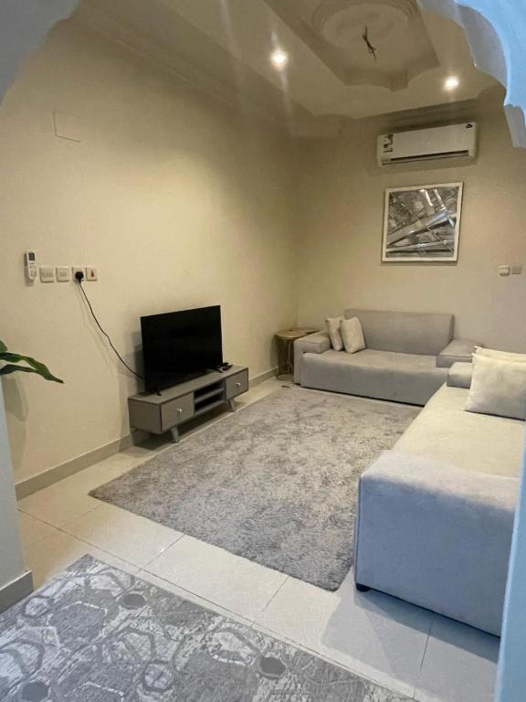 a living room with a couch and a tv at وحدات طيبة in Medina