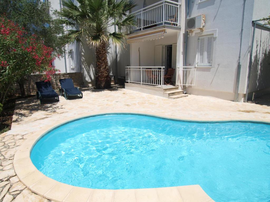 a large swimming pool in a yard with a house at Olea Apartments in Srima