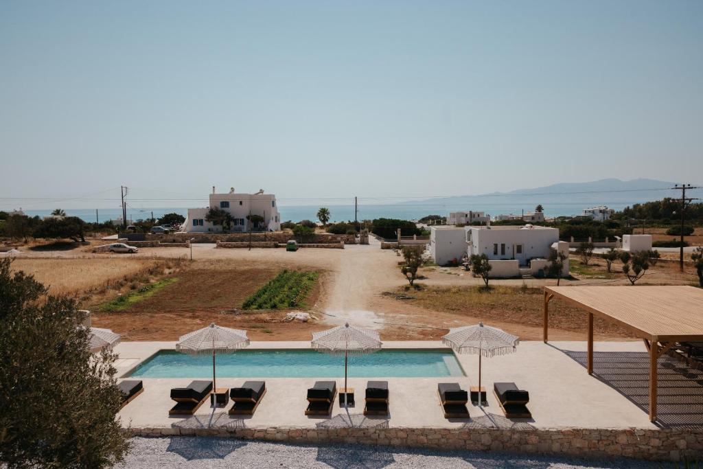a swimming pool with lounge chairs and umbrellas at Phoenicia Nature Naxos in Kastraki Naxou