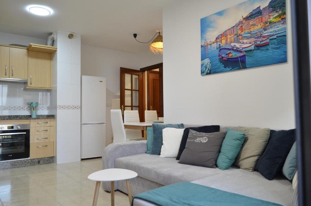 a living room with a couch and a kitchen at Tu Refugio Azul en la Playa -Vilanova de Arousa in Villanueva de Arosa