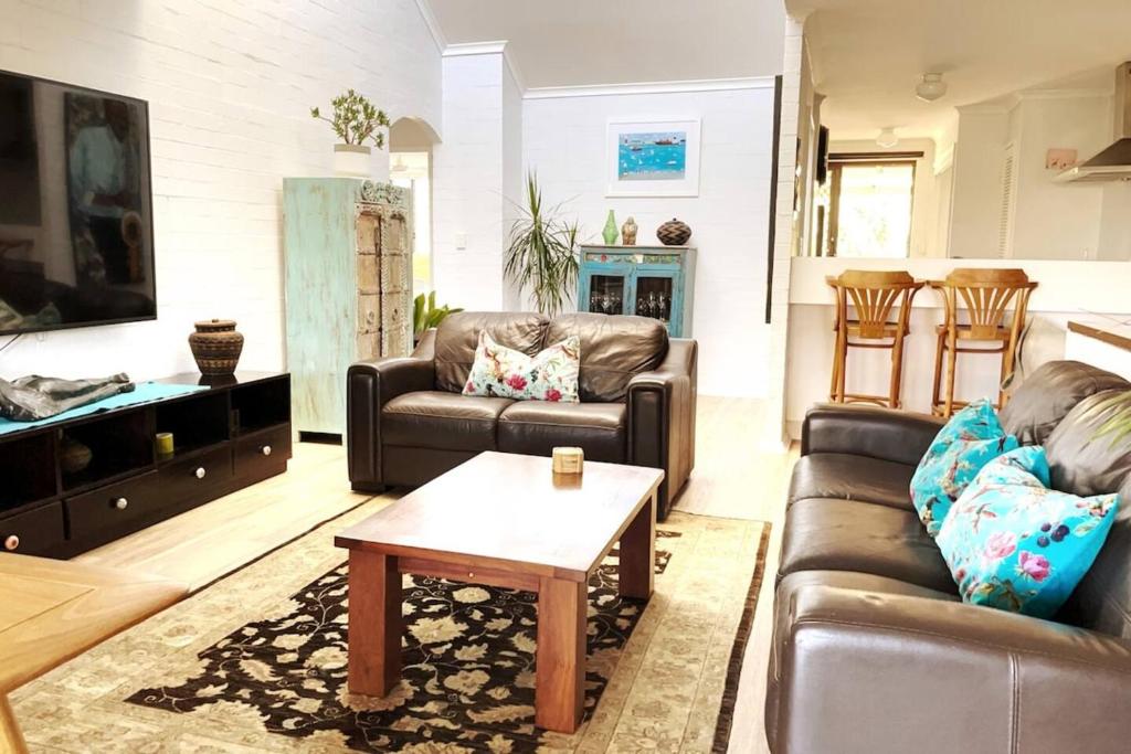 Una sala de estar con dos sofás y una mesa de café. en Sea Breeze Villawalk Everywheresunsets, en Fremantle