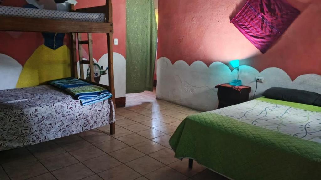 1 dormitorio con 2 camas y una lámpara en el suelo de baldosa en Hostal the Cats, en Panajachel