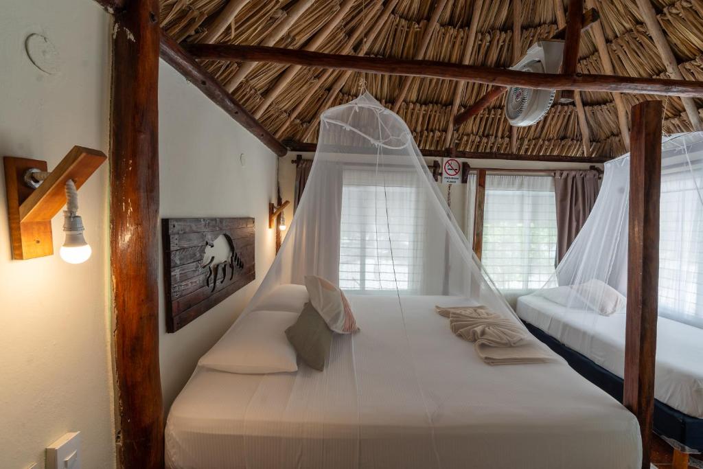 a bedroom with a bed with a mosquito net at Hotel Cielo y Selva in Punta Allen