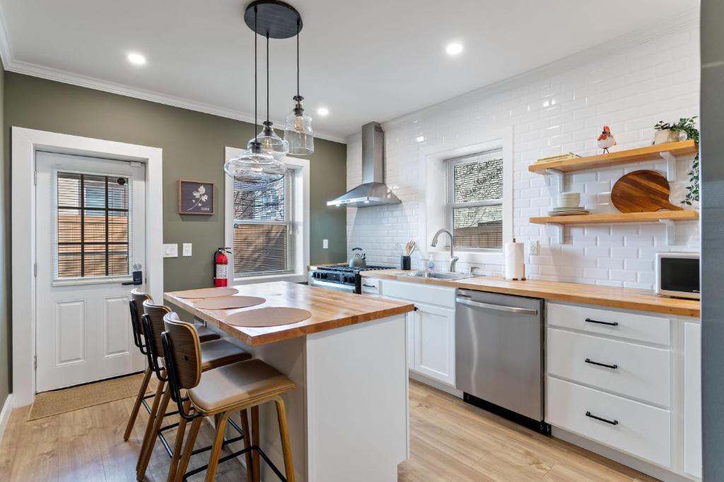 フィラデルフィアにあるWelcome to The Lux Collective a Spacious 5-Bedroom House close to Stadiums, Universities, Center City & more!の白いキャビネットと木製のカウンタートップを備えたキッチン