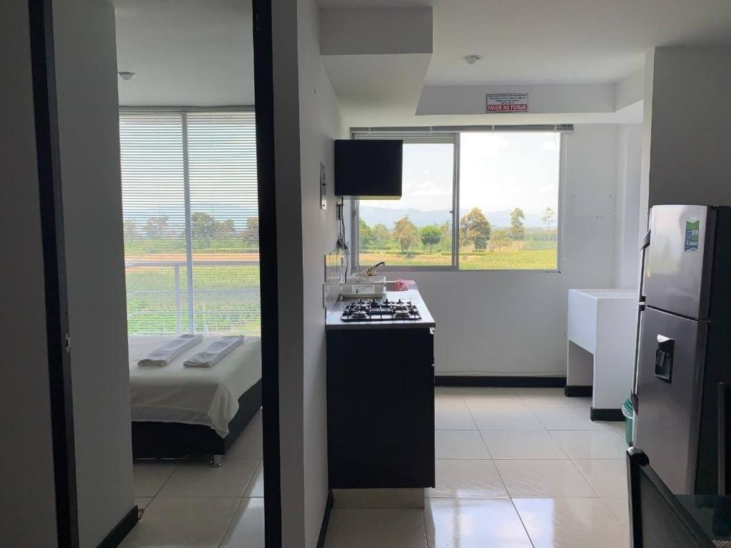 a room with a kitchen with a stove and a bed at Apartamentos con piscina en zona turistica in Montenegro