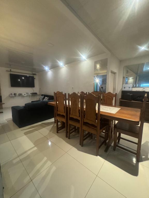 a dining room with a table and chairs and a couch at Casa COP Comfort Belém, 4 Suítes, 9 Hóspedes in Belém