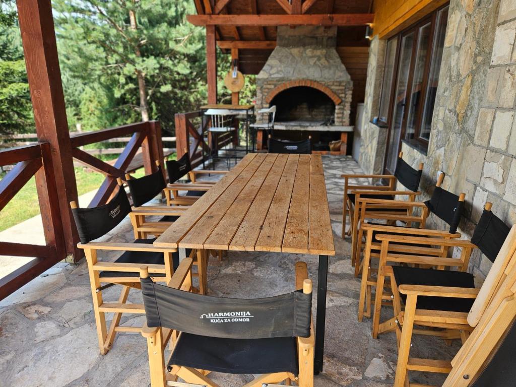 a long wooden table and chairs with a fireplace at Kuca za odmor Harmonija in Pale