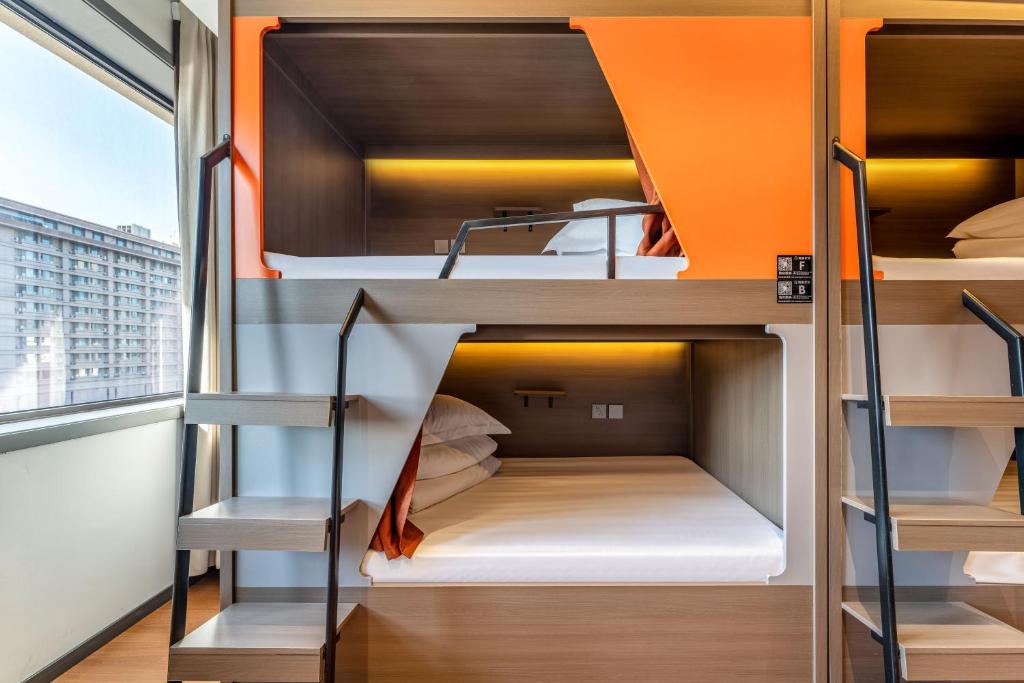 西安市にあるXi'an YOLO Guest Houseのオレンジ色の二段ベッドがある部屋の二段ベッド