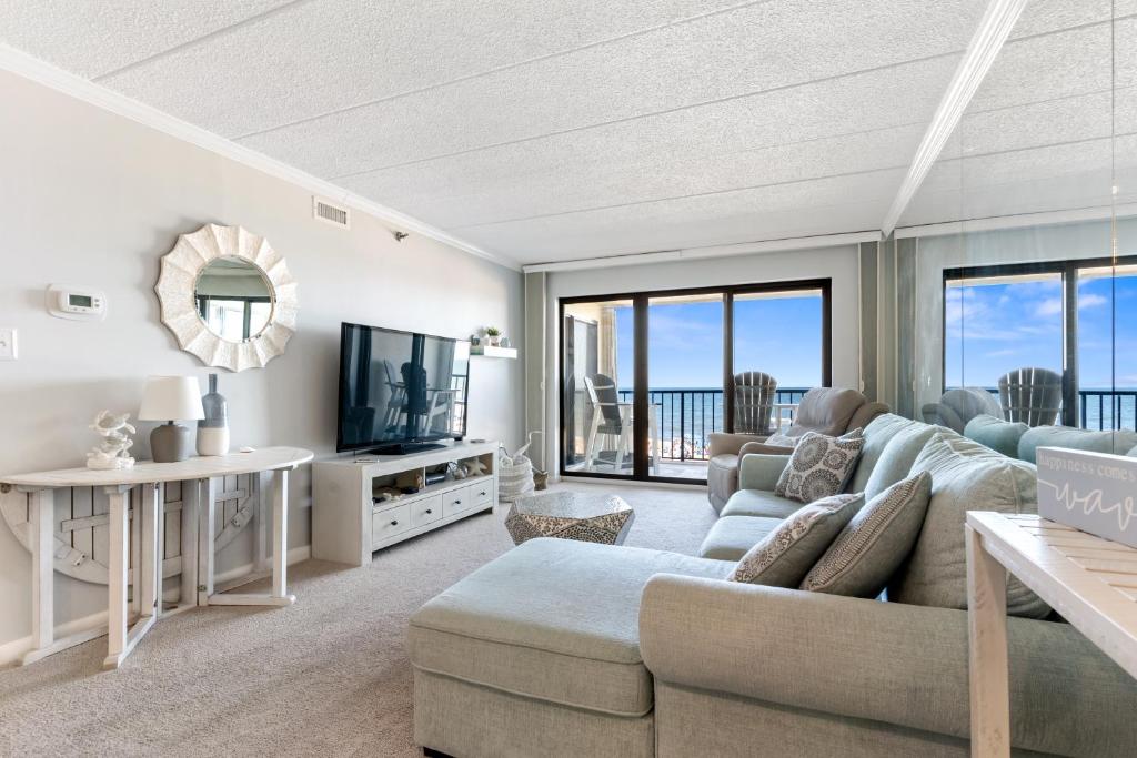 a living room with a couch and a tv at Bright Oceanfront 2BR Condo Balcony, King Bed & Parking in Ocean City