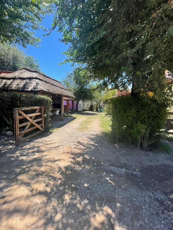 a barn with a thatched roof next to a dirt road at Santa Rosa Cabañas in Santa Rosa de Calamuchita