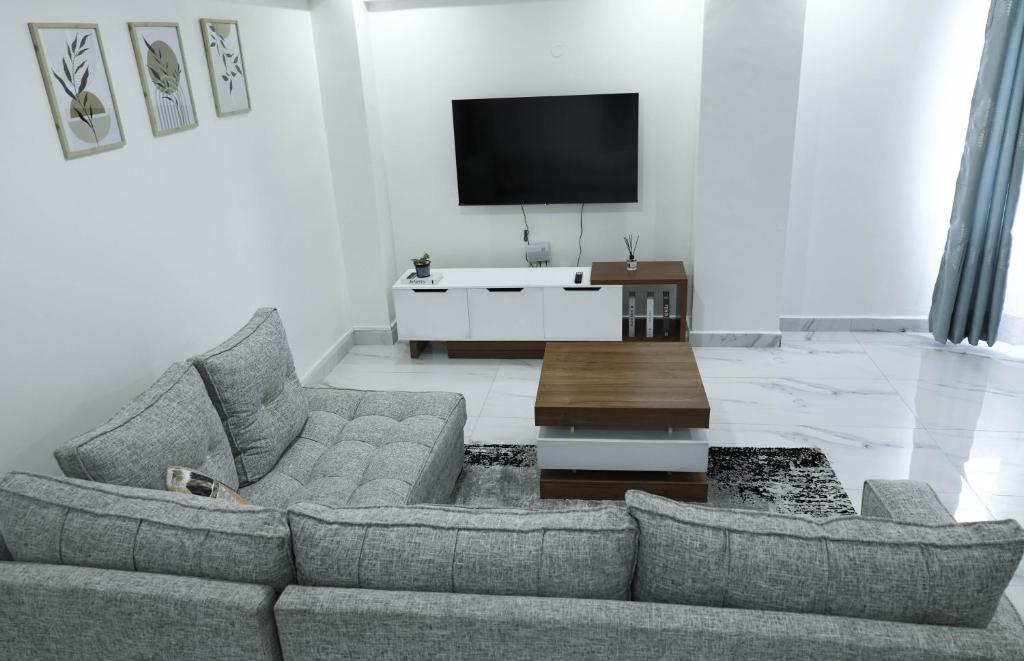 a living room with a couch and a tv at Casa-Koker Residences in Kisumu