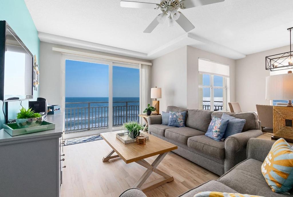 a living room with a couch and a view of the ocean at Beachfront 3br Condo With Stunning Views Daytona in Daytona Beach Shores