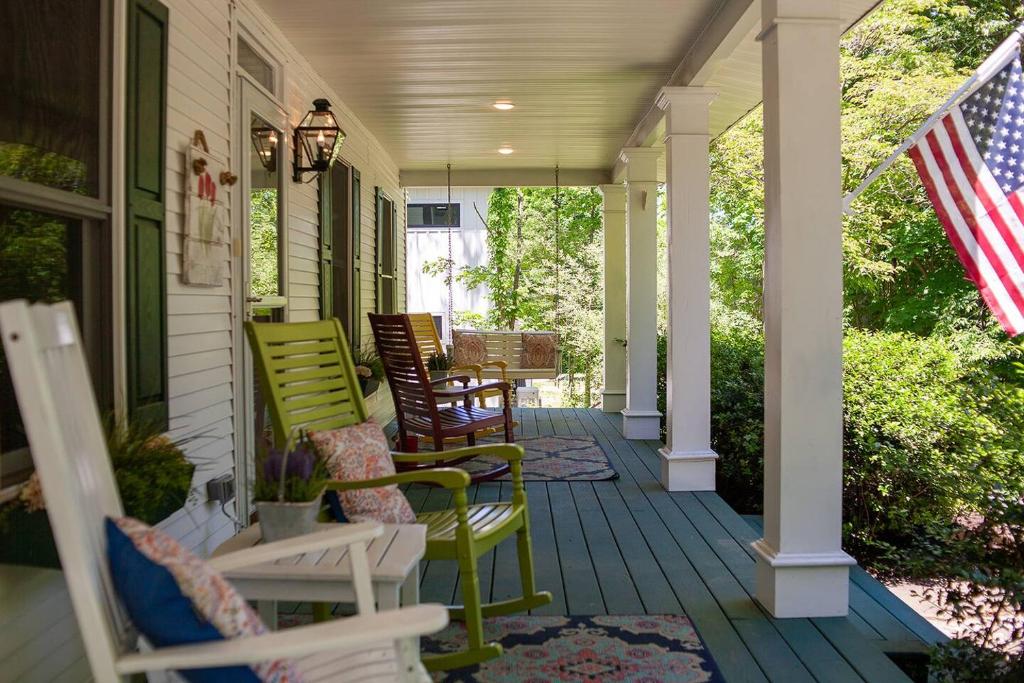 a porch with rocking chairs and an american flag at The Maple House Fully Fenced-in Yard! in Saugatuck
