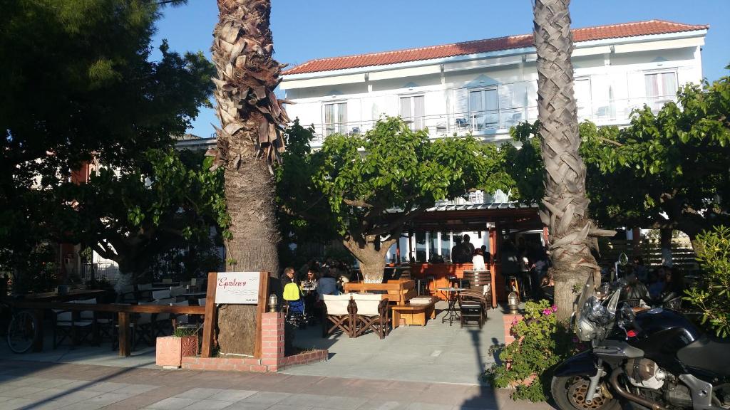 ペフキにあるMirtia Hotelのテーブルと椅子のあるレストラン、木々のある建物
