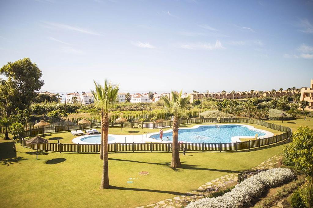 ein großer Pool mit Palmen in einem Park in der Unterkunft Casares Beach in San Luis de Sabinillas