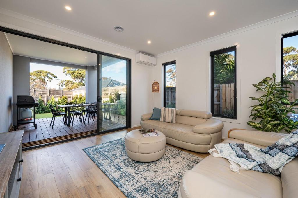 Una sala de estar con dos sofás y una mesa. en Ipanema with spa and moments from the beach, en Safety Beach