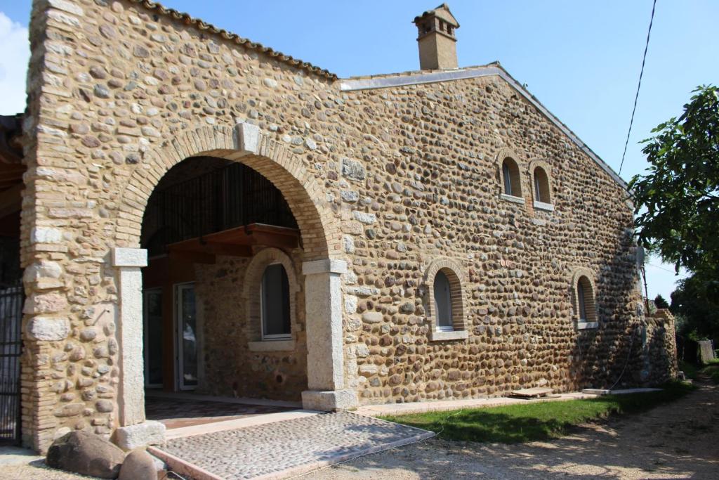 un edificio in pietra con un arco davanti di Giardino degli Ulivi a Caprino Veronese