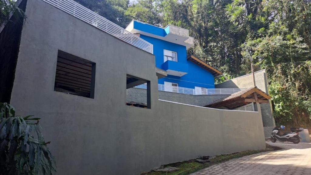 a house with a blue at Casa Aconchegante na Serra da Cantareira em Condomínio Fechado in Mairiporã