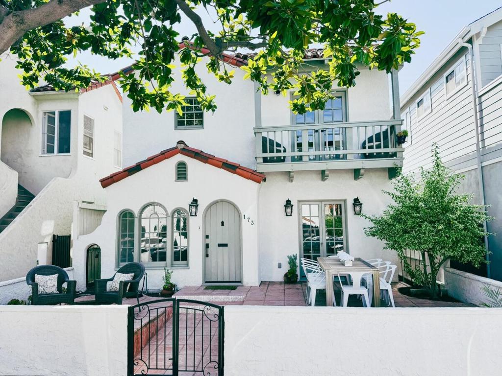 a white house with a table and chairs at Beach Life in Belmont Shore in Long Beach