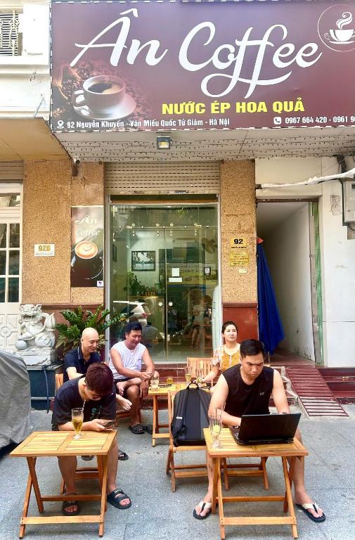 a group of people sitting at tables outside a coffee shop at Ân Coffee in Hanoi