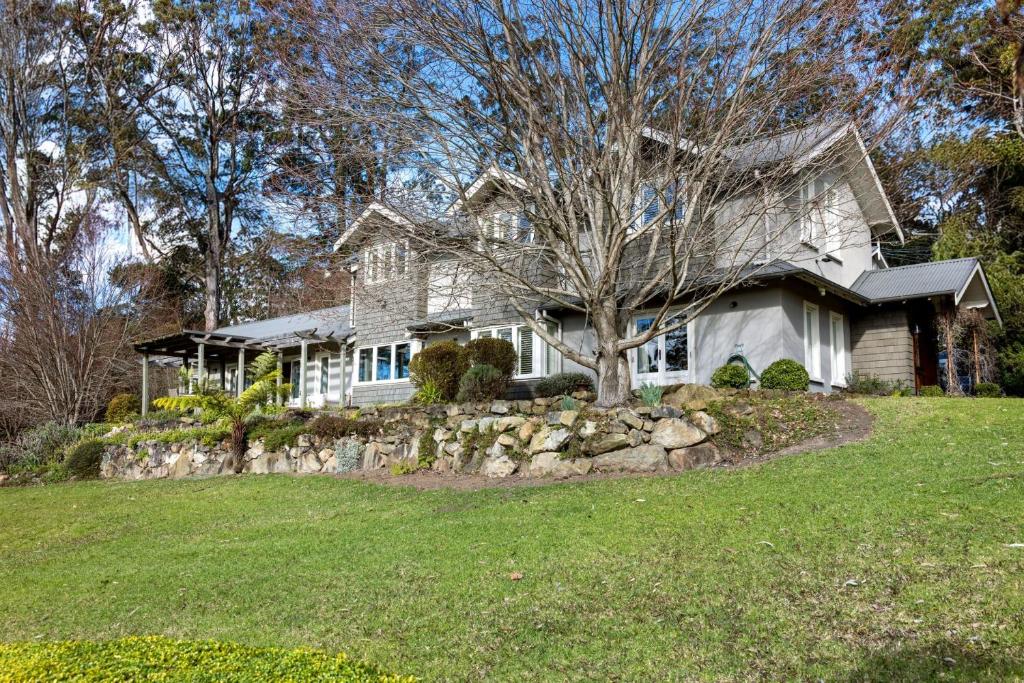 Mulgrave House and Cottage - By Latitude South Coast في Bellawongarah: منزل فيه شجره في الساحه