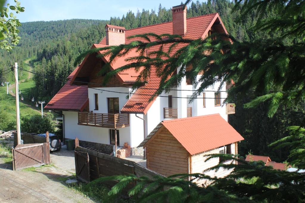 a white house with a red roof at Na Gorbi in Slavske