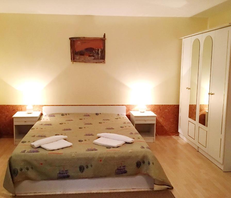 a bedroom with a bed with two night stands and two tables at Vaivorykštė in Nida