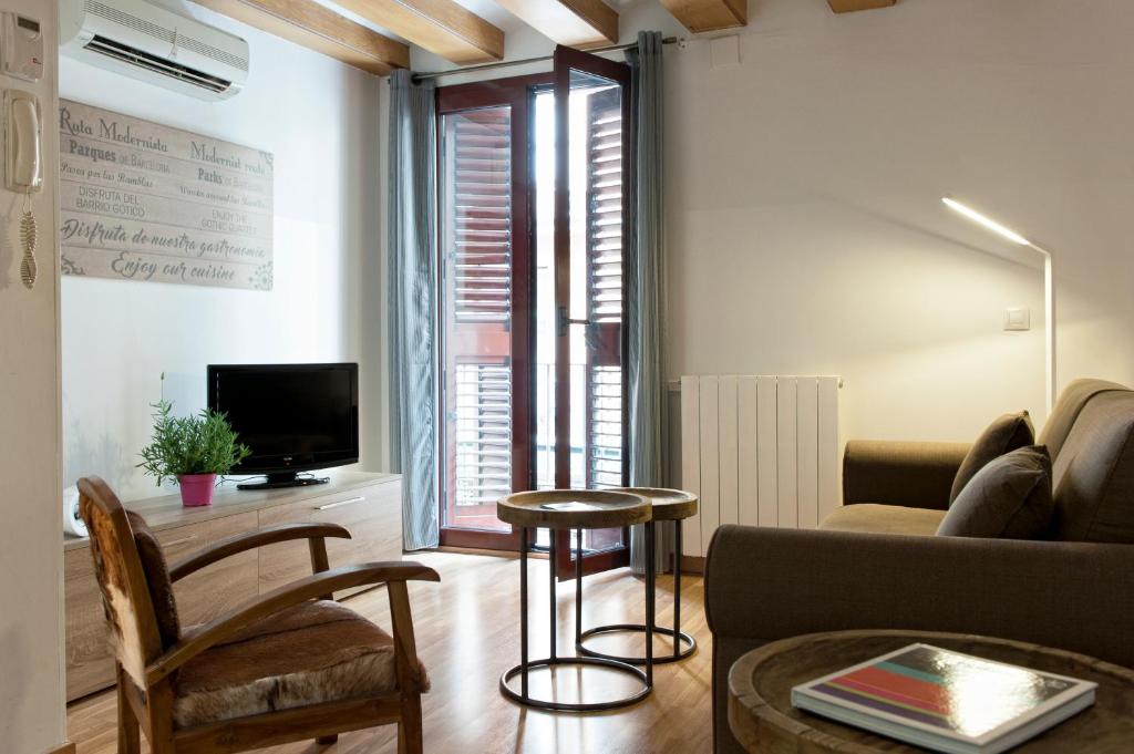 - un salon avec un canapé et une table dans l'établissement MH Apartments Liceo, à Barcelone