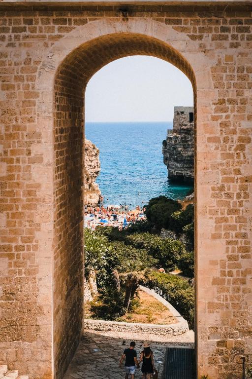 an archway in a brick wall with a view of the ocean at Villa Perla Bianca - Terrazza Panoramica - by Gessica Holiday in Polignano a Mare