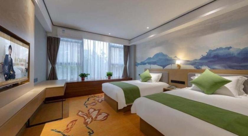 a hotel room with two beds and a tv at Shell Hotel Anhui Huaibei Railway Station Huiyuan Road in Huaibei