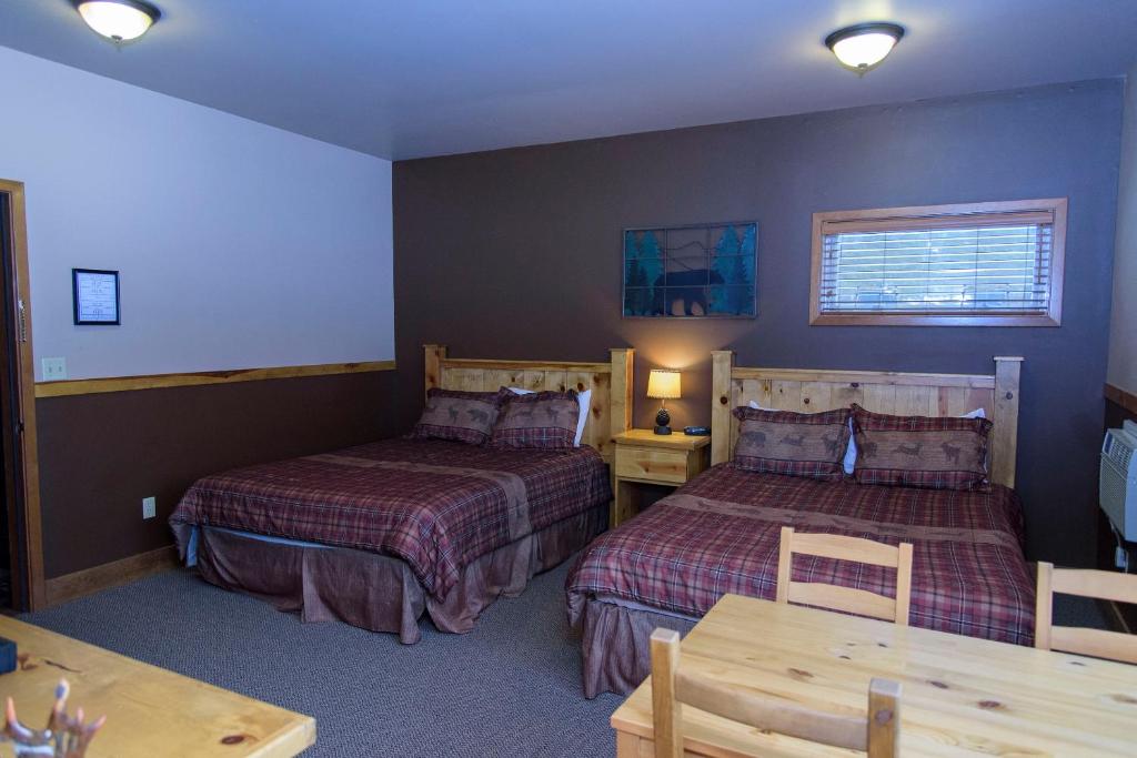 レブンワースにあるLeavenworth Camping Resort Lodge 1のベッド2台とテーブルが備わるホテルルームです。