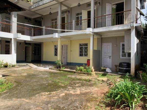een groot appartementencomplex met een tuin ervoor bij Sweet Home Guest House in Shillong